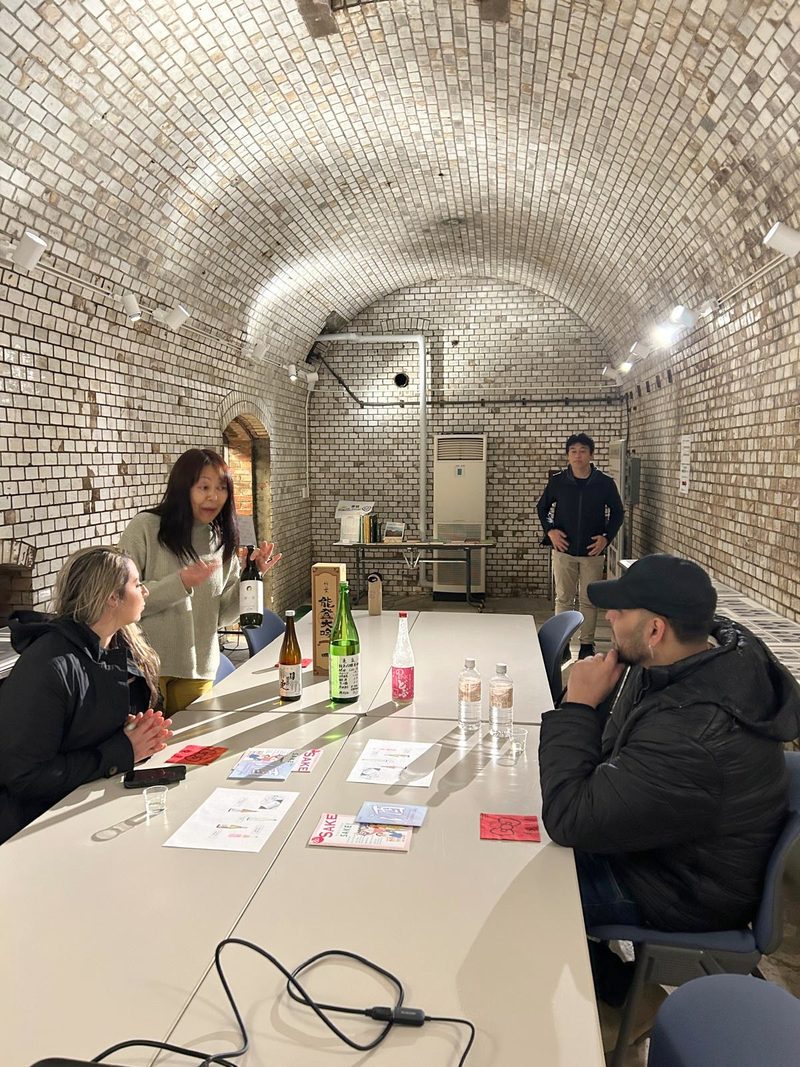 Guests tasting sake in the vaulted red-brick former brewing laboratory