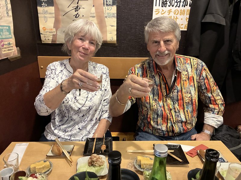 Two guests raising a glass of sake at dinner