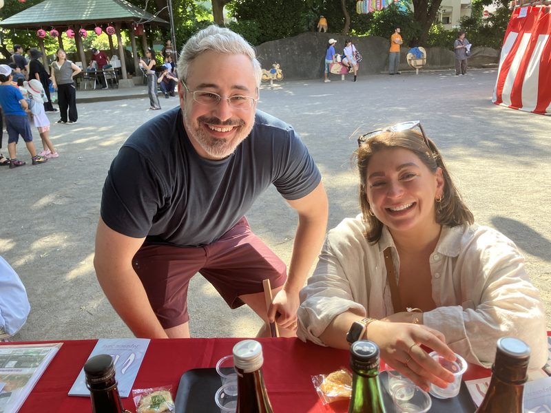 Guests sharing sake at a festival table in the shrine grounds