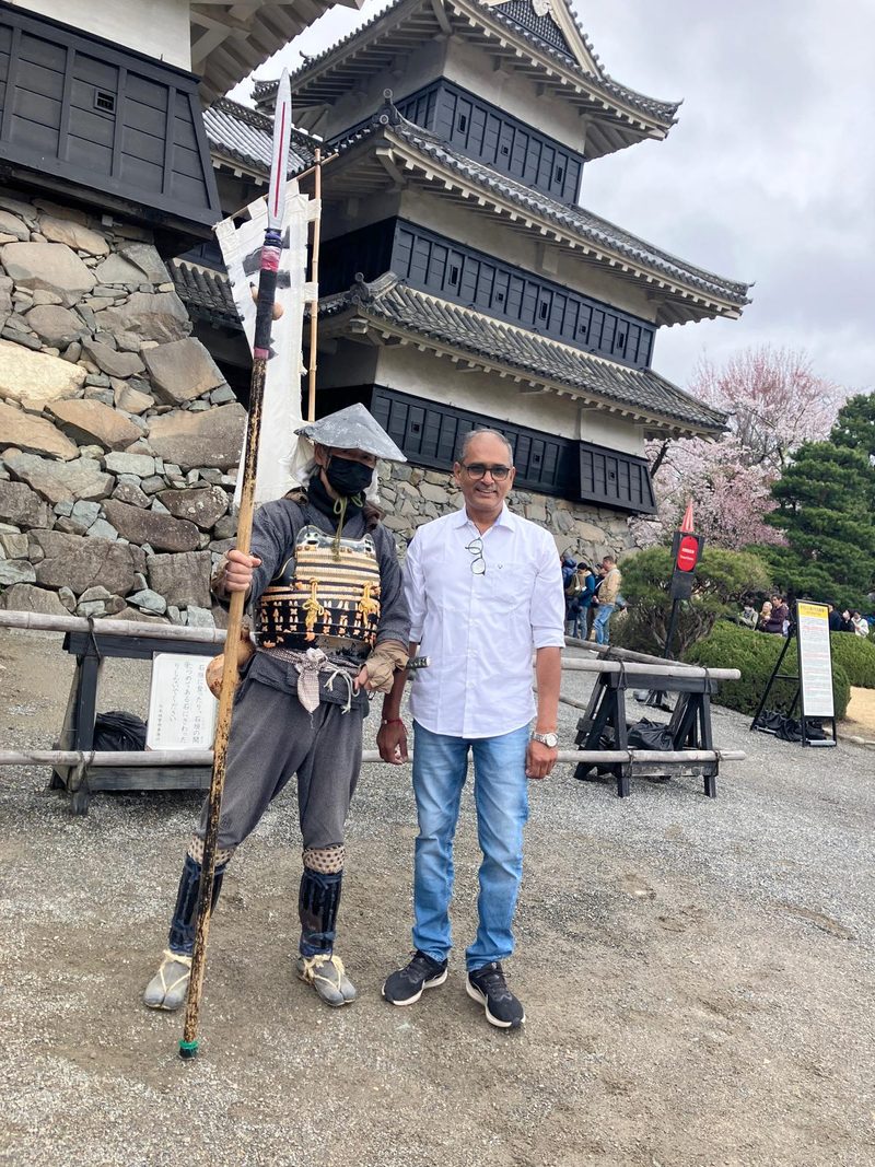 A guest beside a costumed samurai at Matsumoto Castle