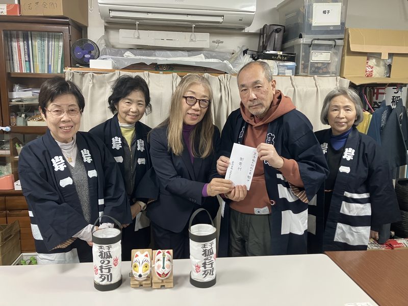 Handing over a donation to the Oji Fox Procession committee — part of every tour fee supports the event