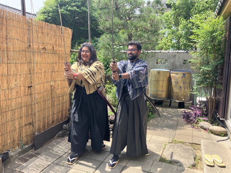 Two guests in hakama holding swords in the sensei’s garden