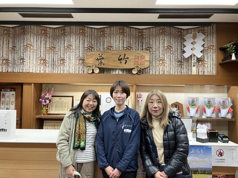 A guide with two guests in the shop of a family sake brewery