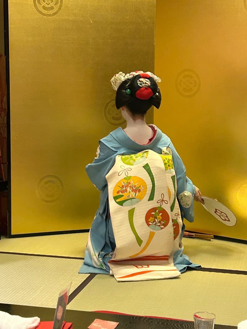 A maiko seen from behind, showing the trailing obi and hair ornaments