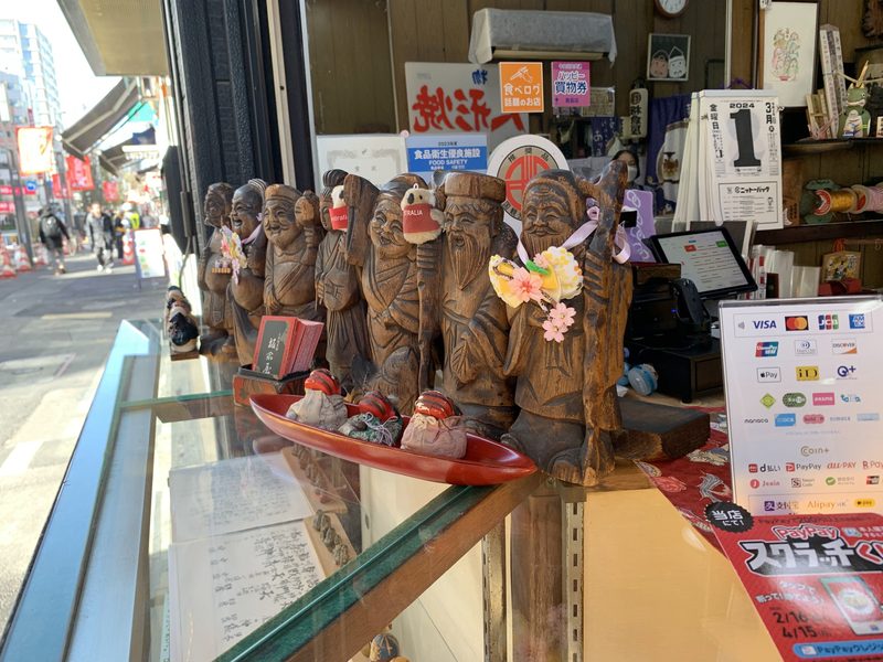 Carved figures of the Seven Lucky Gods in a shop window