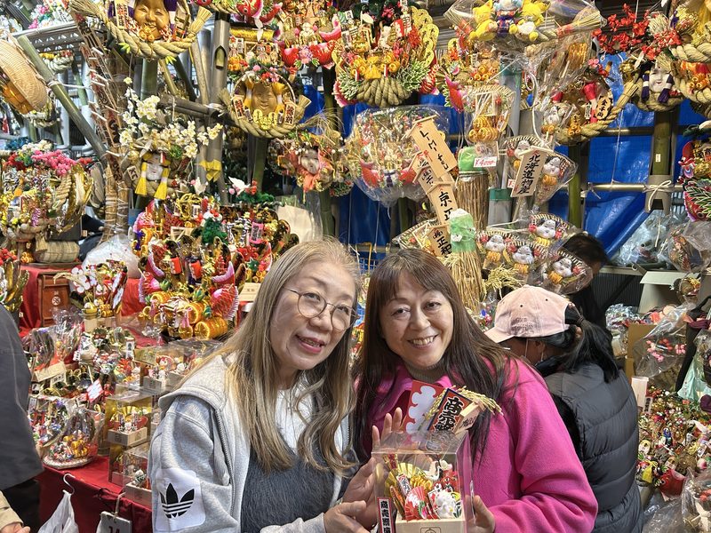 The founders at the Tori-no-ichi fair, holding a decorated kumade rake